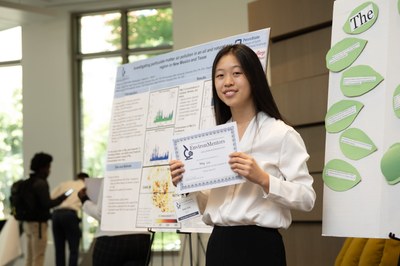 Amy Liu standing beside award winning poster
